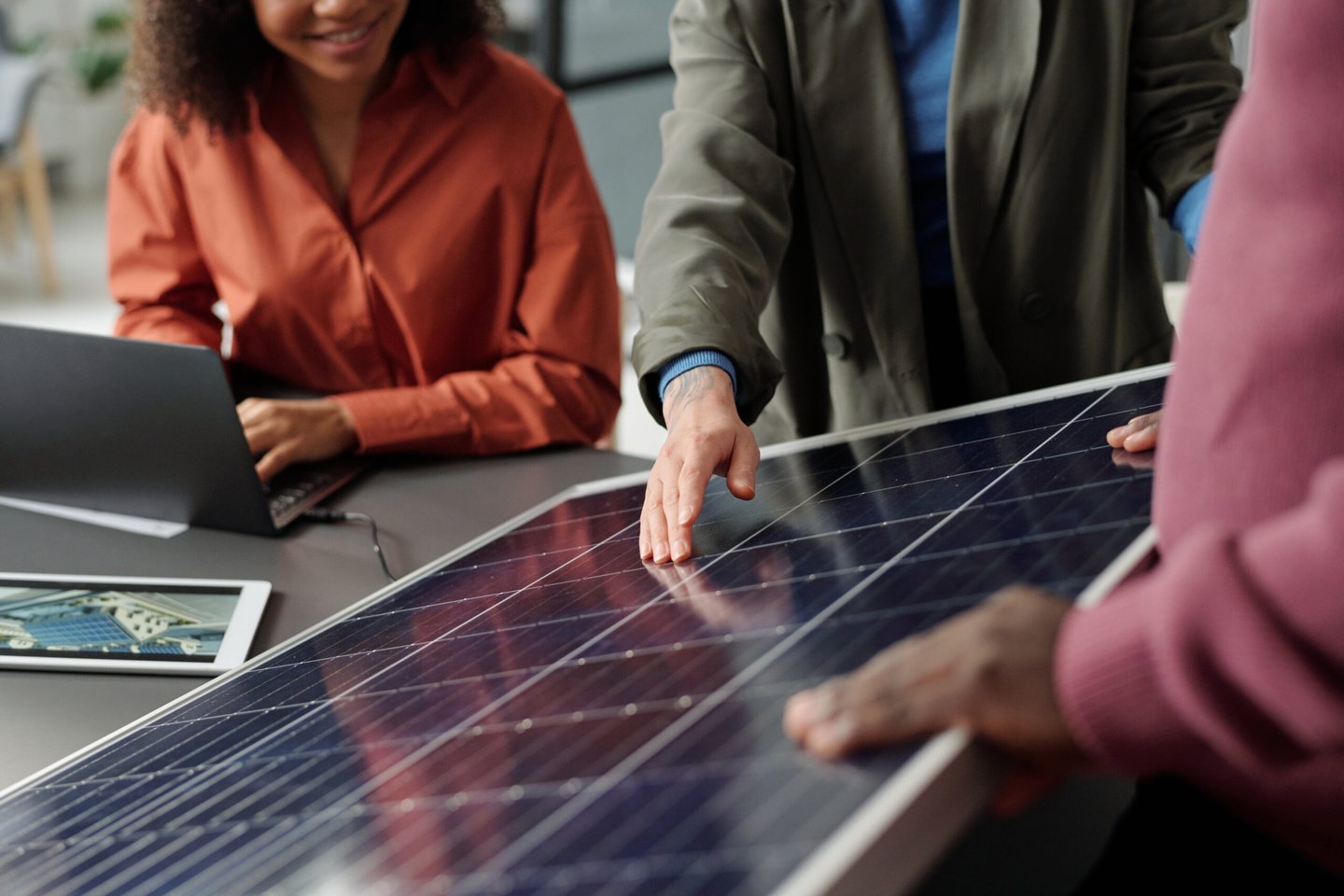 Discussion about solar panels with a solar panel and laptop on a table