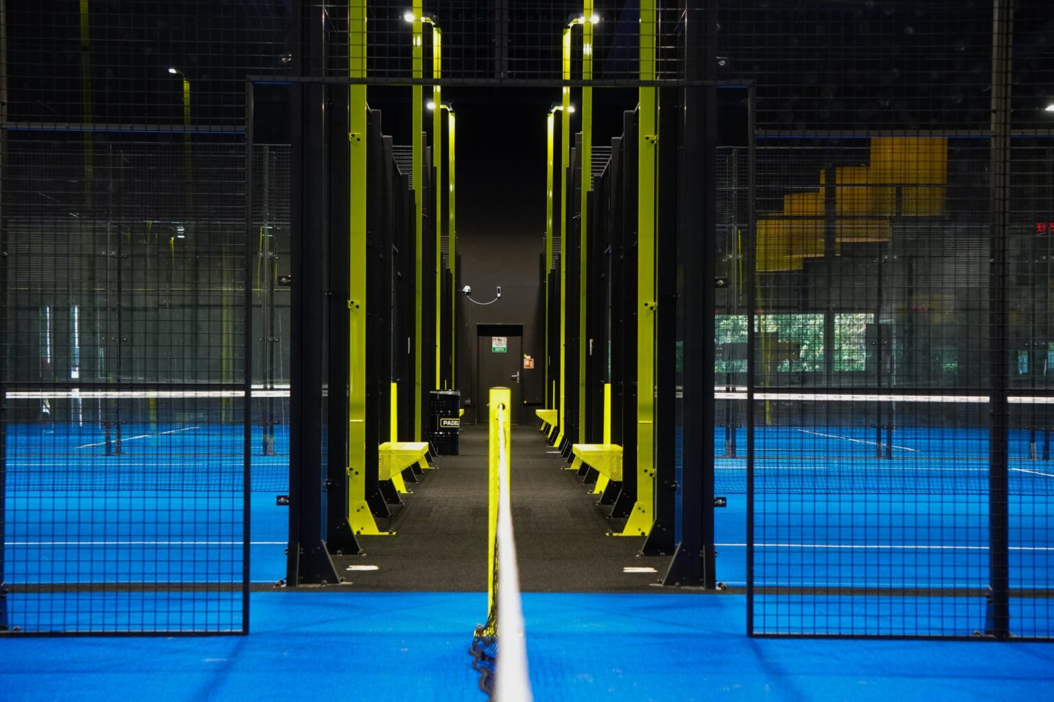 Lit padel courts in an empty hall